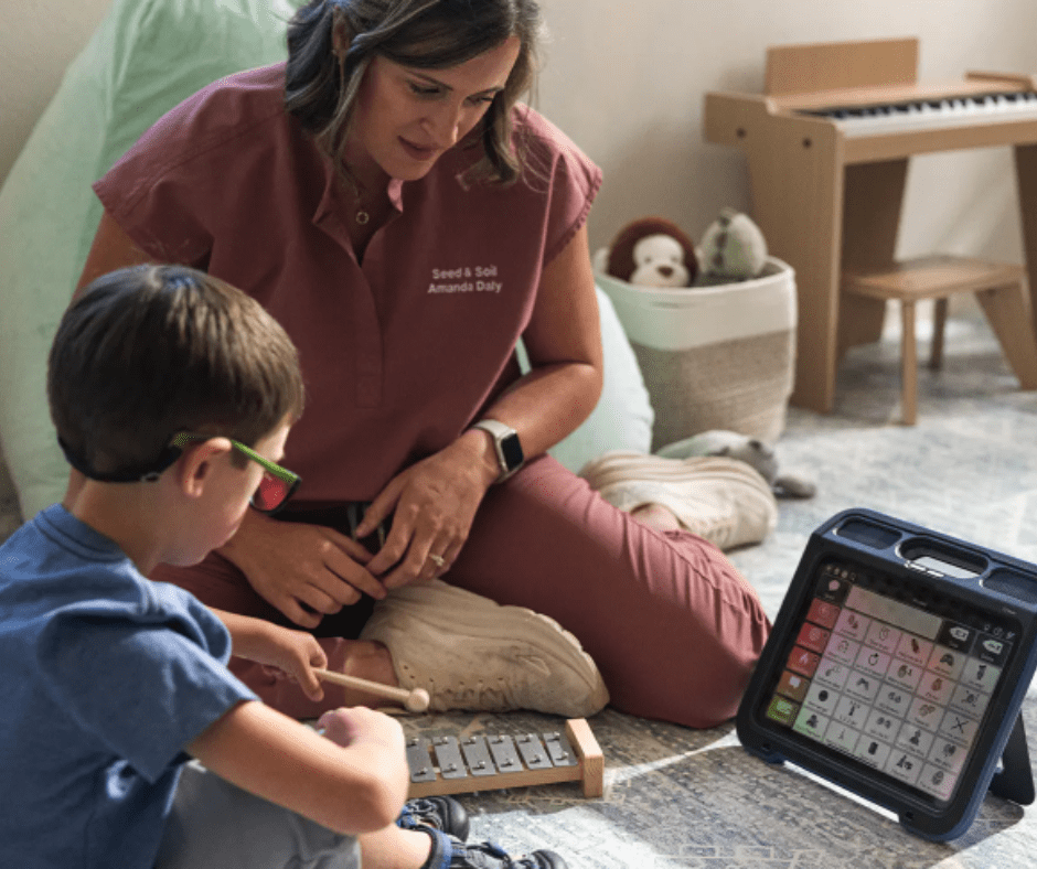 Professionnel de santé accompagnant un enfant autiste avec tablette CAA en prêt