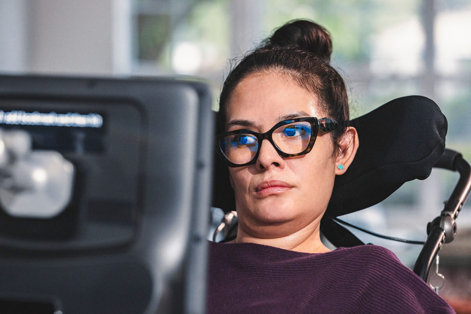 Utilisatrice atteinte de la SLA en fauteuil roulant, communicant avec une tablette à commande oculaire