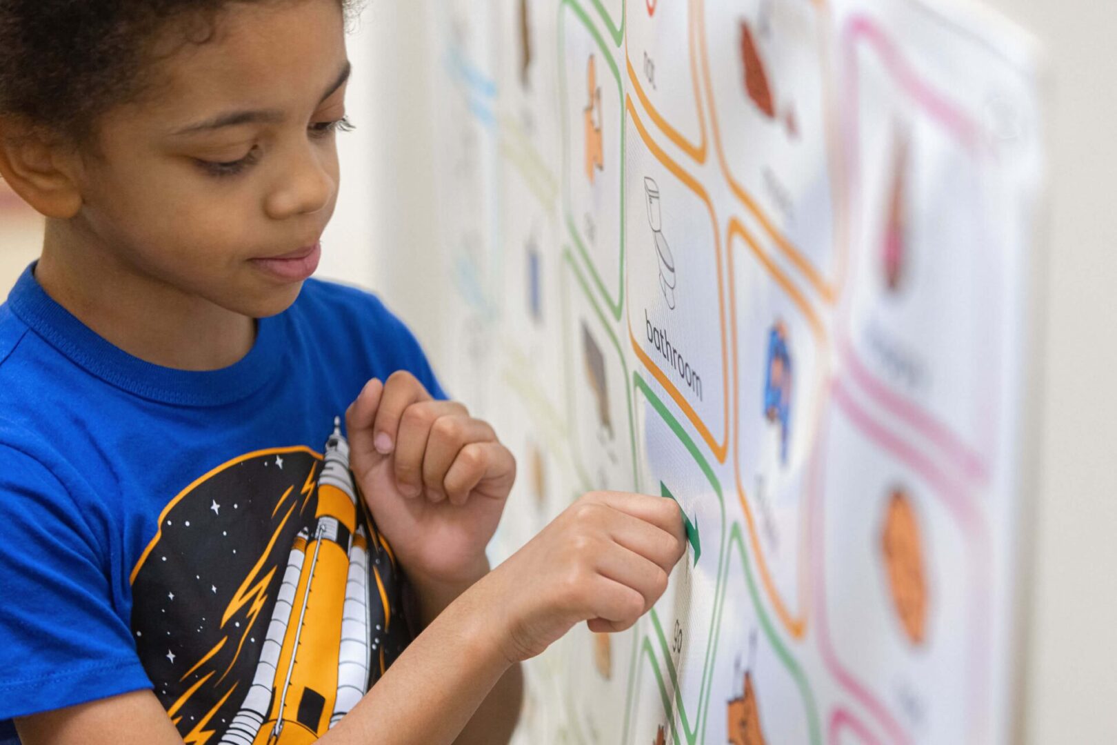 Enfant autiste devant une signalétique de pictogrammes