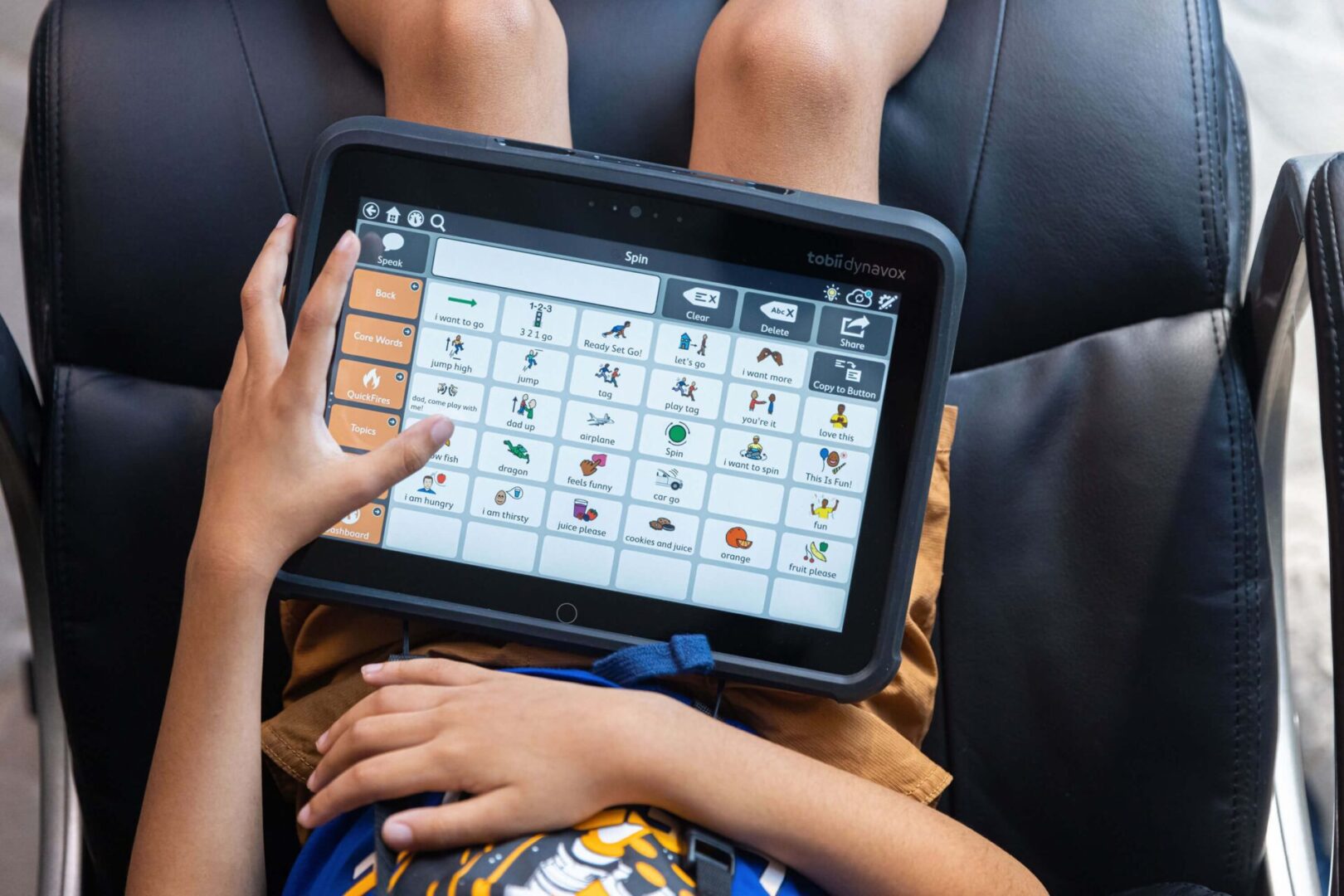 Enfant autiste utilisant une tablette de communication avec pictogrammes